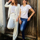 Zwei Frauen mit Sonnenbrillen posieren, die Rechte trägt ein cremeweißes T-Shirt mit weißem love like jesus druck
